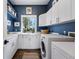 Well-organized laundry room with white cabinets, countertops, and modern washer and dryer at 290 Skyhill Dr, Evergreen, CO 80439