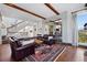Spacious living room with exposed beams, hardwood floors, and a staircase at 290 Skyhill Dr, Evergreen, CO 80439