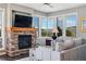 Cozy living room featuring a stone fireplace, large windows, and mountain views at 290 Skyhill Dr, Evergreen, CO 80439