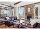 Spacious living room boasts a stone fireplace, hardwood floors, and great views of the outdoors at 290 Skyhill Dr, Evergreen, CO 80439