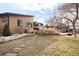 Backyard features a patio with outdoor seating and a swing, with green grass and mature trees surrounding it at 7551 S Garland St, Littleton, CO 80128