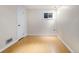 Empty room in the basement featuring bamboo floors, white walls, and one small window at 7551 S Garland St, Littleton, CO 80128