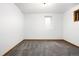 Unfurnished basement space with neutral walls, carpeted floors, and a small window at 7551 S Garland St, Littleton, CO 80128