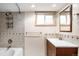 Basement bathroom featuring a tub, shower, vanity, and small window providing natural light at 7551 S Garland St, Littleton, CO 80128
