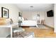 Bright bedroom with a queen bed and white bedding, a decorative desk, and a sliding glass door at 7551 S Garland St, Littleton, CO 80128