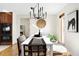 Stylish dining room features modern chandelier, bright window, and views to the cozy fireplace at 7551 S Garland St, Littleton, CO 80128