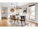 Bright and airy dining room with modern chandelier, white table, and wood floors at 7551 S Garland St, Littleton, CO 80128