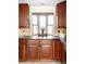 Well-lit kitchen with granite countertops, tile backsplash, and bay window at 7551 S Garland St, Littleton, CO 80128