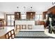 Spacious kitchen with dark wood cabinets, granite countertops, and a center island with seating at 7551 S Garland St, Littleton, CO 80128