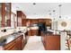 Modern kitchen with dark wood cabinets, granite countertops, and stainless steel appliances at 7551 S Garland St, Littleton, CO 80128