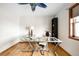 Bright home office with hardwood floors, unique ceiling fan, and glass desk at 7551 S Garland St, Littleton, CO 80128