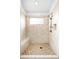 Well-lit walk-in shower with tiled walls, mosaic accents, and built-in bench at 7551 S Garland St, Littleton, CO 80128