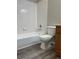 Bathroom with tub and shower, light tile and neutral vinyl flooring at 18784 E Linvale Pl, Aurora, CO 80013