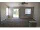 Bright living room featuring a fan, carpet, and natural light from the window and sliding glass door at 18784 E Linvale Pl, Aurora, CO 80013