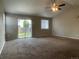 Spacious living room with a fan, carpet floors, neutral walls, and a sliding glass door at 18784 E Linvale Pl, Aurora, CO 80013