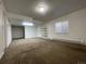 A simple living room with neutral carpeting, a window, and shelving on the wall at 18784 E Linvale Pl, Aurora, CO 80013
