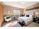 Comfortable bedroom featuring a queen-sized bed, a large window, and neutral tones, and a sitting chair at 10512 Cimarron St, Longmont, CO 80504