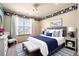 Bright bedroom with blue accents, a comfortable bed, and a sunny window, creating a relaxing atmosphere at 10512 Cimarron St, Longmont, CO 80504