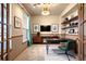 This is an office with built in bookshelves, a desk, TV and a large window for natural light at 10512 Cimarron St, Longmont, CO 80504