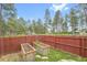 Backyard garden with two raised beds and a red fence around the perimeter of the property at 30400 Hilltop Dr, Evergreen, CO 80439