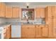 Well-lit kitchen with granite countertops, natural wood cabinets, and a window view at 30400 Hilltop Dr, Evergreen, CO 80439