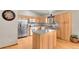Bright kitchen with stainless steel appliances, granite countertops, kitchen island, and light wood cabinets at 30400 Hilltop Dr, Evergreen, CO 80439