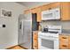 Bright kitchen with stainless steel refrigerator, white range, and light wood cabinetry at 30400 Hilltop Dr, Evergreen, CO 80439