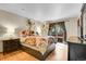 Bright main bedroom with a patterned bedspread, and a sliding glass door to an outside deck at 30400 Hilltop Dr, Evergreen, CO 80439