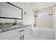 Well-lit bathroom features modern vanity with granite counters, toilet, and tiled shower-tub combination at 8405 W 74Th Dr, Arvada, CO 80005