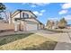 View of a two-story home with an attached garage and long driveway at 8405 W 74Th Dr, Arvada, CO 80005