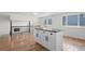 Bright kitchen island with granite counters, white cabinets, and hardwood floors create inviting space at 8405 W 74Th Dr, Arvada, CO 80005