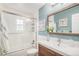 Bright bathroom with a white shower and modern vanity with wood accents, complemented by ocean themed decor at 6871 S Himalaya Way, Centennial, CO 80016