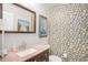 Stylish powder room features a unique mosaic tile accent wall and a modern vanity with a vessel sink at 6871 S Himalaya Way, Centennial, CO 80016