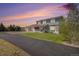 Charming two-story home with a covered front porch and well-manicured lawn under a colorful sunset sky at 6871 S Himalaya Way, Centennial, CO 80016