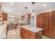Modern kitchen boasts an island with pendant lighting, wood cabinets, stainless steel appliances, and tile flooring at 6871 S Himalaya Way, Centennial, CO 80016
