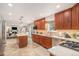 Spacious kitchen featuring tile floors, wooden cabinets, stainless steel appliances, and an island with seating at 6871 S Himalaya Way, Centennial, CO 80016