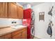 Convenient laundry room with a modern, stackable washer and dryer unit and ample cabinet space for storage at 6871 S Himalaya Way, Centennial, CO 80016