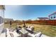 Spacious backyard with patio, wicker furniture, and fire pit, perfect for outdoor gatherings at 13485 Niagara St, Thornton, CO 80602