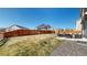 Large, fenced backyard featuring a patio set, a fire pit, and lush green lawn at 13485 Niagara St, Thornton, CO 80602