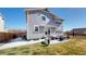 Exterior view of home and patio with wicker furniture, extending into a spacious lawn at 13485 Niagara St, Thornton, CO 80602