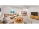 This living room has a sectional couch, a window well, a TV, and an eat-in kitchen in the back at 13485 Niagara St, Thornton, CO 80602
