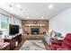 Basement living area featuring a brick fireplace, wood-look flooring, and neutral-toned furniture under recessed lighting at 717 Anderson St, Castle Rock, CO 80104
