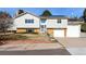 Charming two-story home with light gray siding, brick accents, a well-manicured yard, and solar panels on the roof at 717 Anderson St, Castle Rock, CO 80104