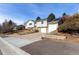 Split-level home featuring gray siding, brick accents, an attached garage, and solar panels against a clear blue sky at 717 Anderson St, Castle Rock, CO 80104