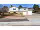 Inviting split-level home featuring light gray siding, brick accents, and a well-manicured front yard with solar panels at 717 Anderson St, Castle Rock, CO 80104