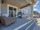 Cozy back porch with wicker furniture, hanging chair, string lights, and composite flooring at 14565 Vancouver Pl, Parker, CO 80134