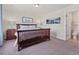 Comfortable bedroom with wood frame bed, wood nightstand and a view to the bathroom at 14565 Vancouver Pl, Parker, CO 80134