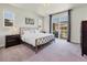 Bright bedroom with a decorative bed frame, outdoor views, and ample natural light from large sliding glass doors at 14565 Vancouver Pl, Parker, CO 80134