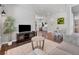Open-concept living room showcasing sleek floors, a modern TV stand, and stylish furniture at 14565 Vancouver Pl, Parker, CO 80134