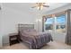 Cozy bedroom featuring neutral walls, plush carpeting, ceiling fan, and a large window offering ample natural light at 6454 Leathers Ln, Parker, CO 80134